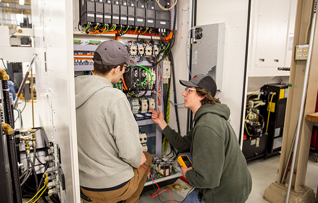 Two Students working on Service Technician Equipment at Anoka Technical College.