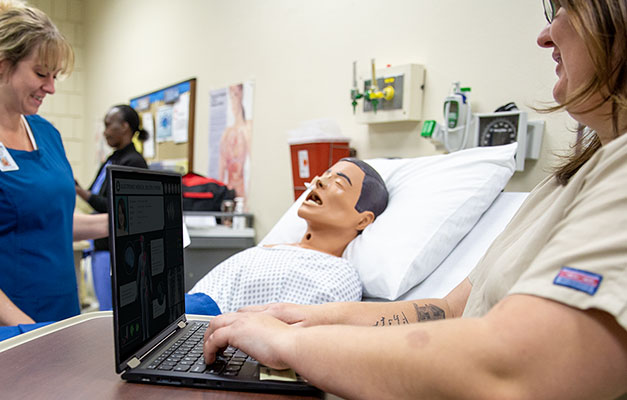 Healthcare Students Learning with a Mannequin in the Lab. 